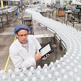 Person inspecting bottles on a conveyor line