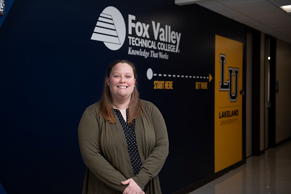 Lakeland University smiles at graduation in cap and gown.