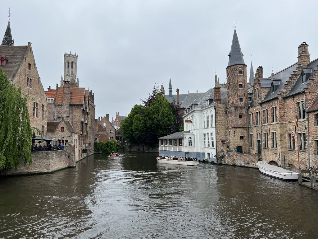 A photo of a river in an European town with boats floating on it