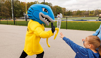 2024 homecoming photo - Musko high-fiving a child