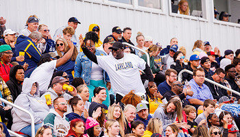 2024 homecoming photo - crowd in bleachers, two people high-fiving
