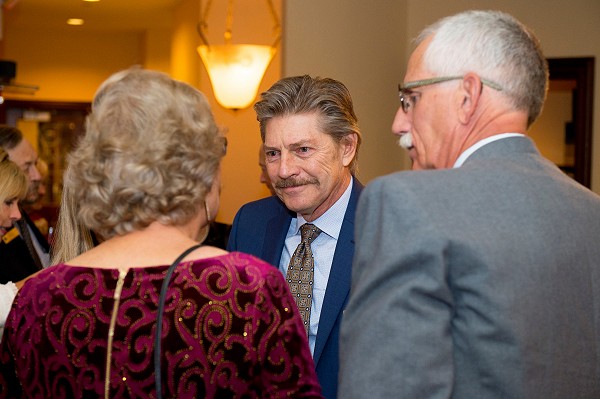 Lakeland University affiliates smile while having a conversation at a ceremony.