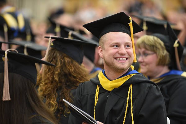 Lakeland University alumni smiles at graduation ceremony