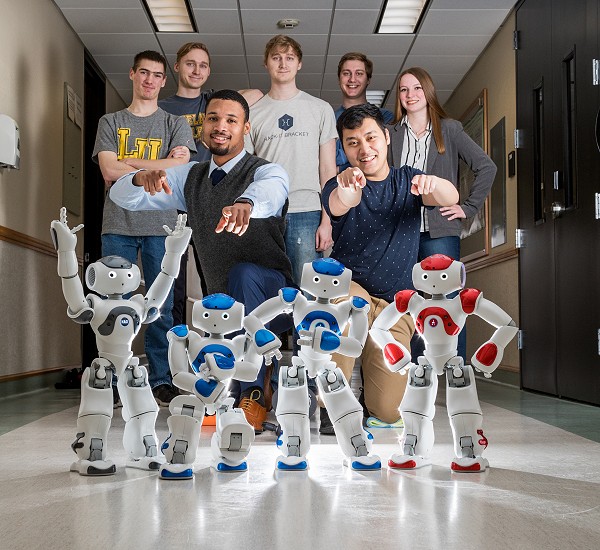Computer Science students posing for picture with Lakeland robots.