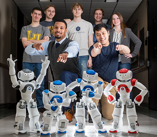 Lakeland University computer science majors posing with school robots.